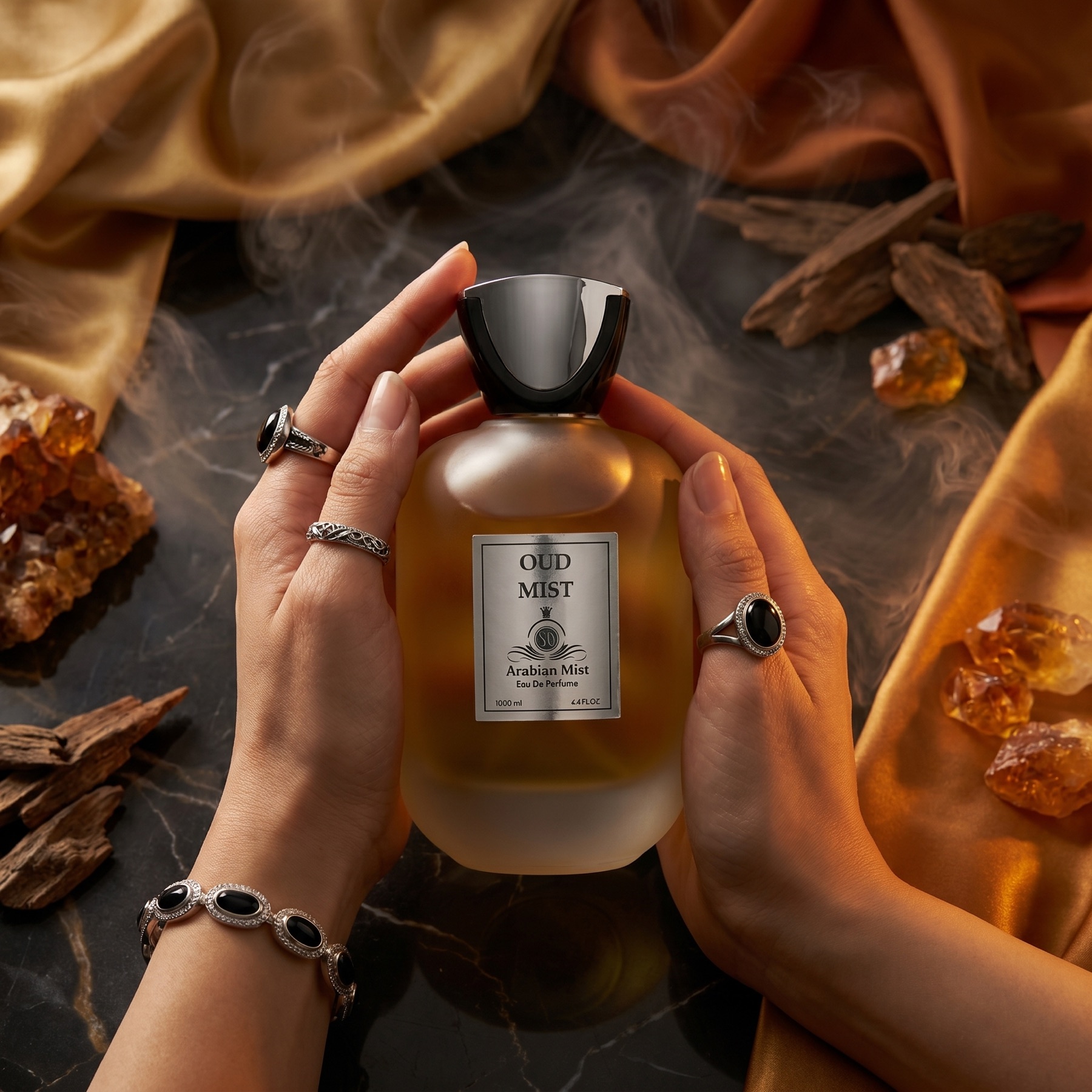Arabian Mist Oud perfume on dark marble with amber crystals and gold silk